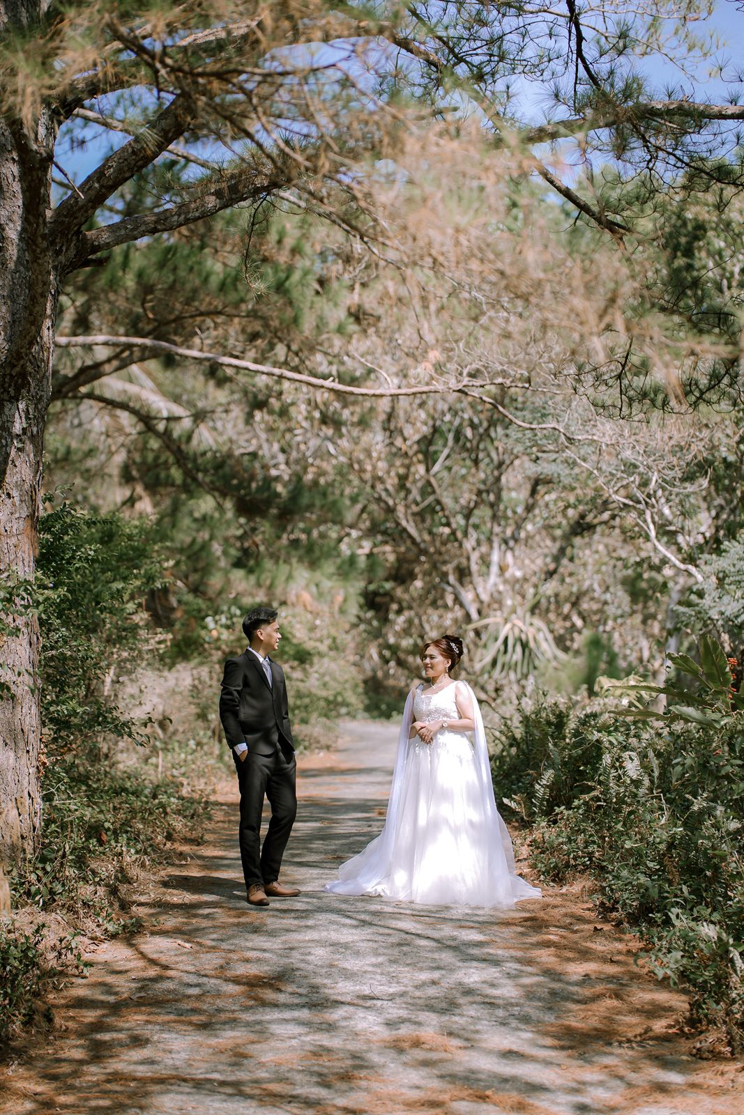 Caren and Zayrol looking at each other in wedding attire